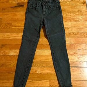 Madewell button front black wash skinny jean with frayed ankle detail.